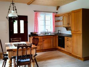 a kitchen with wooden cabinets and a table and a window at Nusseckerl Eberloh in Halfing +7 photos