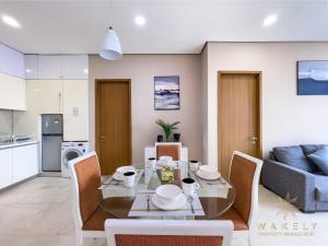 a living room with a table and chairs and a kitchen at Soho Suites KLCC by Wakely Kuala Lumpur in Kuala Lumpur