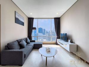 Soho Suites KLCC by Wakely Kuala Lumpur في كوالالمبور: غرفة معيشة مع أريكة وطاولة