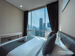Soho Suites KLCC by Wakely Kuala Lumpur في كوالالمبور: غرفة نوم بسرير ونافذة كبيرة