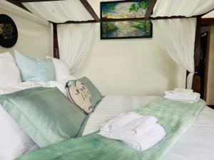 Una cama con toallas encima. en Sharods Self-catering Guesthouse, en Ciudad del Cabo