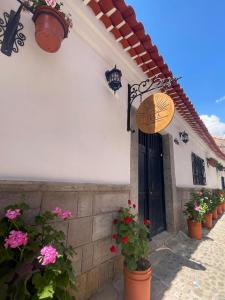 a building with potted plants and a door with flowers at Illa B&B in Cusco
