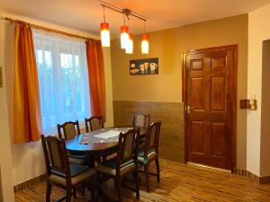 comedor con mesa, sillas y puerta en Vadrózsa Vendégház-Apartman en Demjén