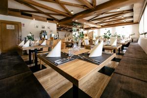 a dining room with wooden tables and chairs at Hotel Bacher in Riva di Tures