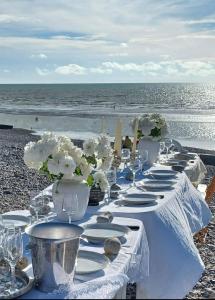 a long table with plates and vases on the beach at Gîte d’Eros in Saint-Valery-sur-Somme