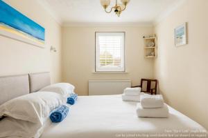 um quarto com uma cama com lençóis brancos e uma janela em Chimneys em Poole