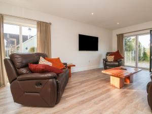 a living room with a leather couch and a coffee table at Linden View in Ilfracombe