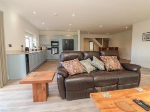 a living room with a brown leather couch and a table at Linden View in Ilfracombe