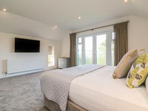 a bedroom with a large bed and a large window at Linden View in Ilfracombe