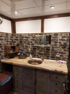 a bathroom with a sink and a stone wall at Къща за гости Георги Божилов - Слона in Plovdiv