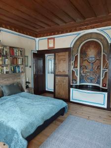 ein Schlafzimmer mit einem großen Bett und einem Bücherregal in der Unterkunft Къща за гости Георги Божилов - Слона in Plowdiw