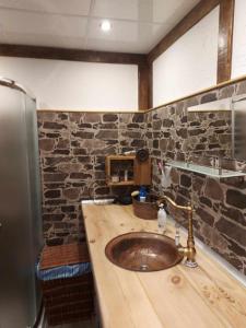 La salle de bains est pourvue d'un lavabo et d'un mur en pierre. dans l'établissement Къща за гости Георги Божилов - Слона, à Plovdiv