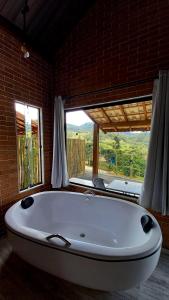 REFUGIO PIEMONTE Chalés في سوكورو: حوض استحمام كبير أبيض في غرفة مع نافذة