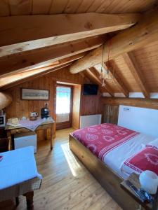 Un dormitorio con una cama grande en una habitación con techos de madera. en B&B Marcellina, en Bard