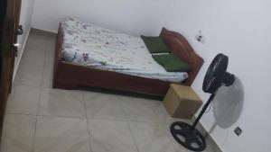 a small bed sitting in a room with a lamp at Maison paisible abomey calavie in Cotonou