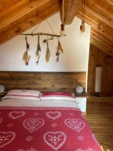 a bedroom with a bed with a red bedspread at B&B Marcellina in Bard