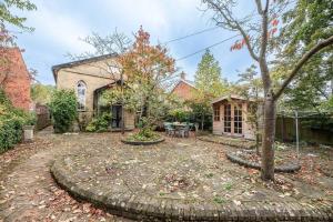 un gran patio con una casa y un árbol en The Old Chapel, Wissett en Halesworth