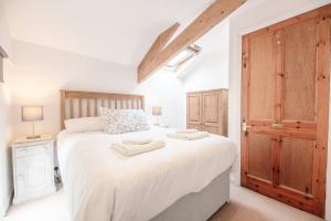 a bedroom with a large white bed with two towels on it at The Old Chapel, Wissett in Halesworth