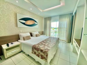 a bedroom with a large bed and a window at Hotel Paradiso del Sol in Cabo Frio