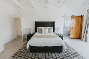 Schlafzimmer mit einem großen Bett mit einem schwarzen Kopfteil in der Unterkunft Stunning Luxury Villa Home with breathtaking views! in Helensvale