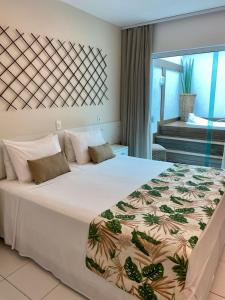 um quarto com uma grande cama branca com em Hotel Paradiso del Sol em Cabo Frio