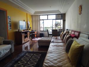uma sala de estar com um sofá e uma televisão em Shamanic Home no Rio de Janeiro