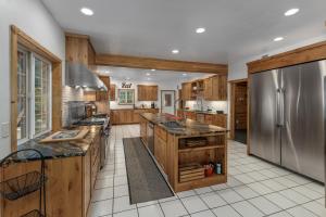una cucina con mobili in legno e un frigorifero in acciaio inossidabile di River Road Lodge by NW Comfy Cabins a Leavenworth