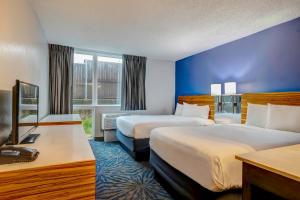 Habitación de hotel con 2 camas y TV en Motel 6 Arlington TX Entertainment District, en Arlington