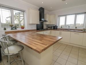 a kitchen with white cabinets and a wooden counter top at The Meadows in Pentraeth