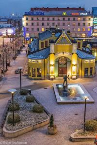 un grande edificio giallo con una statua davanti di City Apartment Snellmaninkatu 22 A a Kuopio