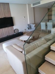 uma sala de estar com um sofá e uma mesa em Mangroovy 2BR with roof em Hurghada