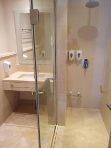 a bathroom with a shower with a sink and a mirror at Mangroovy 2BR with roof in Hurghada