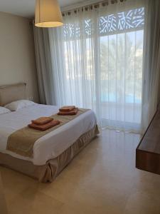 a bedroom with a large bed and a large window at Mangroovy 2BR with roof in Hurghada