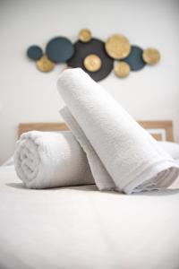 a stack of towels and buttons on a bed at Nautical Flats by Concept in Valencia