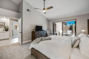 a bedroom with a large bed and a sliding glass door at Beautiful Condo with Mountain & Sunset Views! in Palm Desert +51 photos