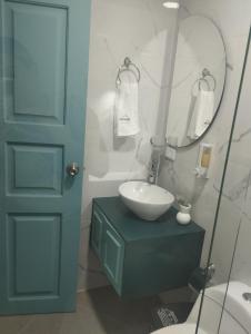 W łazience znajduje się umywalka i lustro. w obiekcie Hotel Chromatic w mieście Guatapé