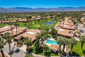 an aerial view of a resort with a pool and palm trees at Beautiful Condo with Mountain & Sunset Views! in Palm Desert
