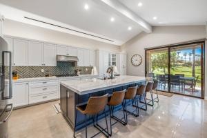 a kitchen with a large island with bar stools at Beautiful Condo with Mountain & Sunset Views! in Palm Desert