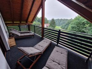 a screened in porch with chairs and beds on it at Holiday Home Rajf in Donji Koncovčak