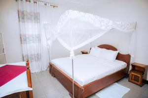 a bedroom with a bed with a canopy at Peace Guest House in Muhari