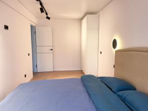 a bedroom with a blue bed and a closet at Apartment Dzerzhinskogo in Ustʼ-Kamenogorsk