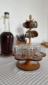 - un plateau avec des verres et une bouteille sur une table dans l'établissement Casa Viorica -Botoș, à Ciocăneşti