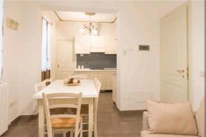 een keuken en eetkamer met een witte tafel en stoelen bij Ca Briani DX in Venetië +7 foto's