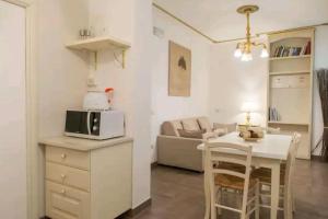 een keuken en een woonkamer met een tafel en een magnetron bij Ca Briani DX in Venetië