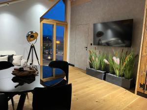 un soggiorno con un tavolo e una tv di ROYAL HILL II a Białka