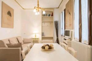 een woonkamer met een tafel en een bank bij Ca Briani DX in Venetië
