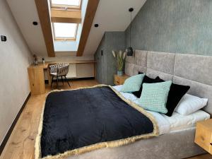 Un dormitorio con una cama grande y una mesa. en ROYAL HILL II, en Białka Tatrzanska