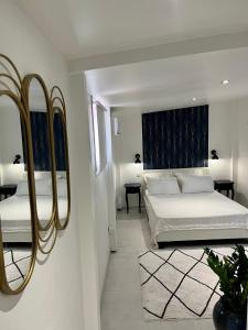 a bedroom with two beds and a large mirror at Casa Hugo - Guest Suites in Fort-de-France