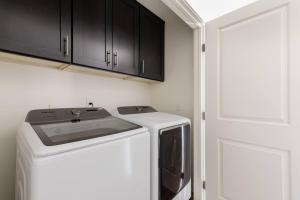 a washer and dryer in a small kitchen at Modern Home with Hot Tub + Open Desert Views + Hammocks + Fire Pit + Game Room in Joshua Tree