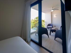 ein Schlafzimmer mit einem Bett und ein Zimmer mit einem Fenster in der Unterkunft Space and comfort for your beach vacation in Punta Cana